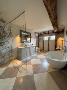 a large bathroom with a tub and a sink at Surrey Barn, Newly Renovated in Ripley +103 photos