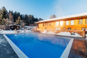 a swimming pool in the snow next to a building at Luxus Suite mit Whirlpool im Hotel Rupertihof in Ainring