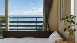 a bedroom with a bed and a view of the ocean at Yangyang Haetteuneun Changmun Pet-Friend in Yangyang