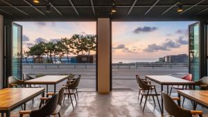 a restaurant with tables and chairs and a view of the ocean at Yangyang Haetteuneun Changmun Pet-Friend in Yangyang