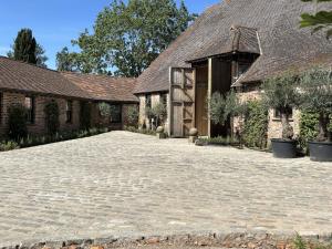 a brick house with a driveway in front of it at Surrey Barn, Newly Renovated in Ripley