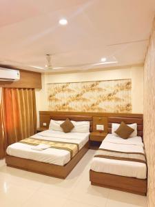 a bedroom with two beds at Crystal Luxury Hotel in Mumbai