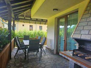 a patio with a table and chairs and a fireplace at Вила Магнолия in Lakarevo