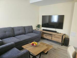 a living room with a couch and a flat screen tv at Вила Магнолия in Lakarevo