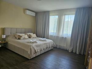 a bedroom with a bed with two towels on it at Вила Магнолия in Lakarevo +17 photos