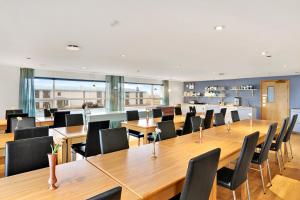a conference room with a long wooden table and chairs at Eldey Airport Hotel in Keflavík