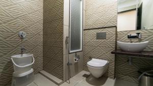 a bathroom with a toilet and a sink at Hotel Pinaki Inn in Ujjain