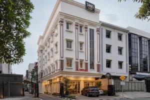 a white building with a sign on top of it at Sans Vibes Flamenco Hotel in Jakarta
