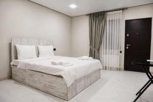 a bedroom with a large bed with white sheets at SkyGate Hotel in Pʼarakʼar