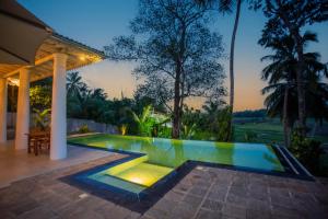 a swimming pool in the backyard of a villa at Legato House in Talpe