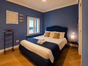 a blue bedroom with a bed with towels on it at La Casa Del Pittore - Centro Storico in Legnano +13 photos