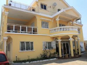 a yellow house with a balcony at K.méléon-Hôtel in Ivato