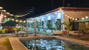a swimming pool in front of a building with lights at Oceanaire Beach Resort ELYU in Bacnotan