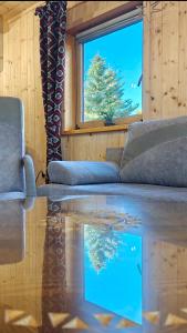 a living room with a couch and a window and a fish tank at Domki u Jacka - Rodzinny Relaks w Górach, SPA i atrakcje dla dzieci in Ząb