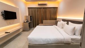 a hotel room with a bed and a television at Hotel Pinaki Inn in Ujjain