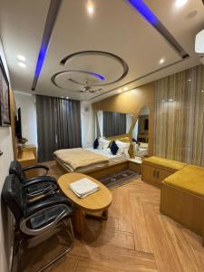 a room with a bed and a table and chairs at HOTEL ELiTE in Pānīpat