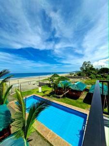 a view of the beach from a resort with a swimming pool at Oceanaire Beach Resort ELYU in Bacnotan
