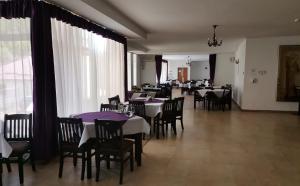 a dining room with tables and chairs with purple tablecloths at Hotel Venus in Slănic-Moldova +23 photos