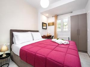 a bedroom with a large pink comforter on a bed at Victor Junior Suite by "elite" in Zakynthos