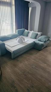 a large bed in a room with a couch at Apart Central in Orşova