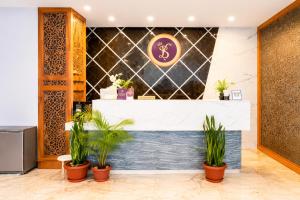 a lobby with potted plants in front of a counter at Hotel Ram krishna Residency in Brahmapur