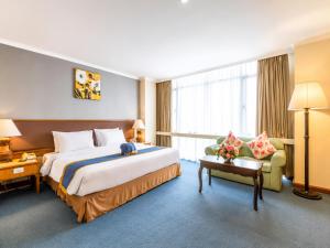 a hotel room with a large bed and a chair at Hotel Ram krishna Residency in Brahmapur