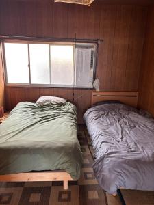 a small bedroom with a bed and a window at ゲストハウス奥白浜 in Shirahama