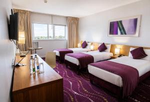 a hotel room with three beds and a television at Louis Fitzgerald Hotel in Clondalkin +45 photos