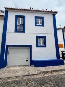 a blue and white house with a garage at Refugio dos Lima in Ericeira