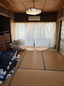 a room with a room with a window and a bed at ゲストハウス奥白浜 in Shirahama