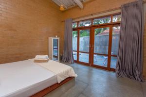 a bedroom with a bed and a large window at Legato House in Talpe +39 photos