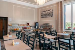 a restaurant with tables and chairs and a chandelier at Lilium Hotel in Florence