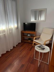 a living room with a tv and a chair and a table at Casa Maria in Olivenza