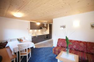 ein Wohnzimmer mit einem Sofa und einem Tisch in der Unterkunft Dorfappartements Söll in Söll