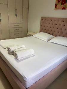 a bedroom with a bed with towels on it at Sunshine Apartment in Sarandë