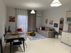 a living room with a table and a couch at Sunshine Apartment in Sarandë