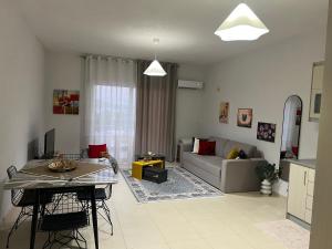 a living room with a table and a couch at Sunshine Apartment in Sarandë