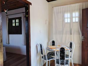 a table and chairs in a room with a window at Chalé Panorâmico in Ouro Preto