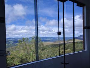 a window with a view of a mountain view at Chalé Panorâmico in Ouro Preto