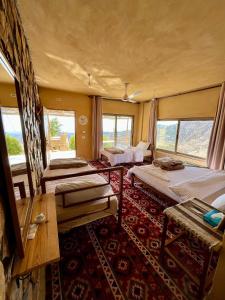 a bedroom with two beds in a room with windows at Wild Dana Eco Lodge- Hotel-Eco-Camp in Dana