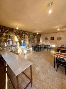 a restaurant with tables and chairs and a stone wall at Wild Dana Eco Lodge- Hotel-Eco-Camp in Dana