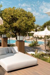 a white bed sitting on a wooden deck next to a pool at Grand Hotel Gallia in Milano Marittima