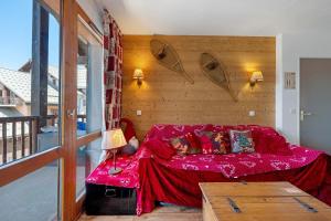 a living room with a red couch in a room at Valmeinier le Miras in Valmeinier