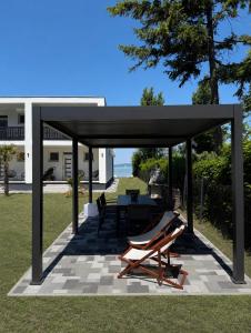 a pavilion with two lounge chairs and a table at BALATON A KERTBEN - BALATON IN THE GARDEN - Beachfront villas with beautiful view, private beach in Balatonfenyves +34 photos
