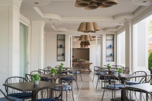 a group of tables and chairs in a room with windows at Grand Hotel Gallia in Milano Marittima