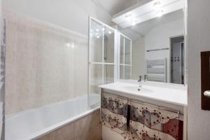 a bathroom with a sink and a tub and a mirror at Valmeinier le Miras in Valmeinier +15 photos