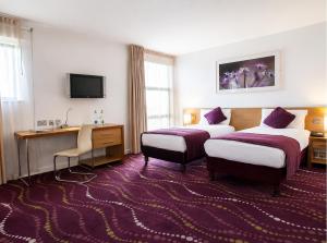 a hotel room with two beds and a desk at Louis Fitzgerald Hotel in Clondalkin