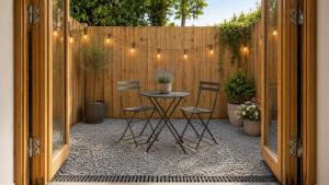 a patio with a table and chairs and a fence at Cymyran Terrace in Holyhead