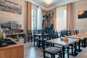 a restaurant with tables and chairs and a chandelier at Astrid Hotel in Florence