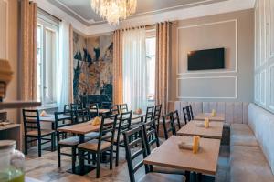 a restaurant with tables and chairs and a chandelier at Astrid Hotel in Florence